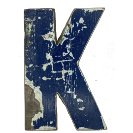 Houten letter K gemaakt van oude vissersbootjes